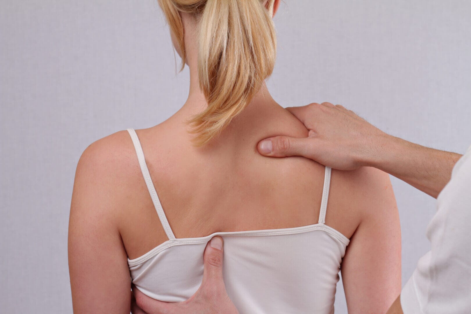 Osteopathie in der Frauenheilkunde. Auf diesem Bild sieht man eine osteopathische Behandlung am Rücken einer Frau.
